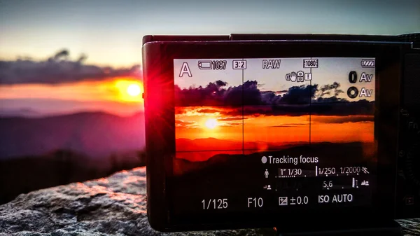 Λαμβάνοντας sunset photo με μια φωτογραφική μηχανή στα βουνά — Φωτογραφία Αρχείου