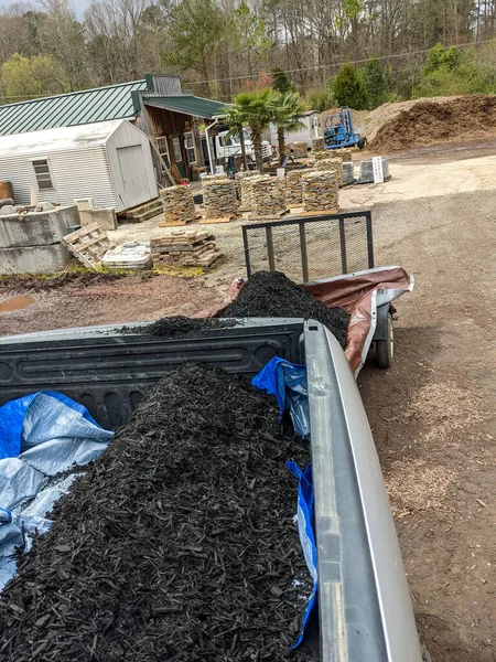 front loader filling pickup and trailer with black mulch