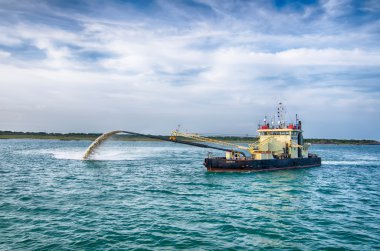 Barge Pipe pushing sand onto the beach clipart