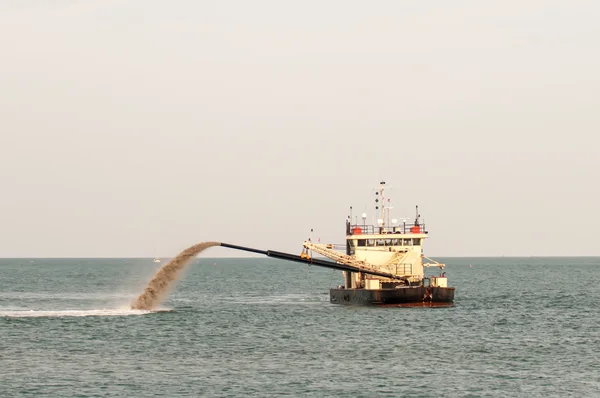 Barge pijp duwen zand op het strand — Stockfoto