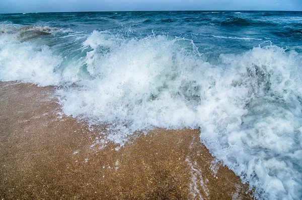 Mare con onde e spiaggia di sabbia Foto Stock Royalty Free