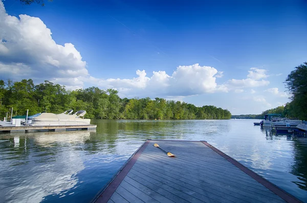 Lodě v doku na jezeře s modrou oblohou — Stock fotografie