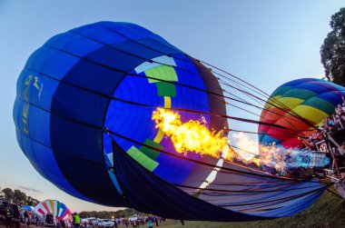 Ateş, balon festivalinde sıcak hava balonunun içindeki havayı ısıtıyor. 