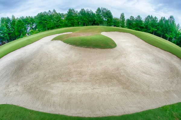 Grönt gräs av den golfbana som omges av en höstlig skog — Stockfoto