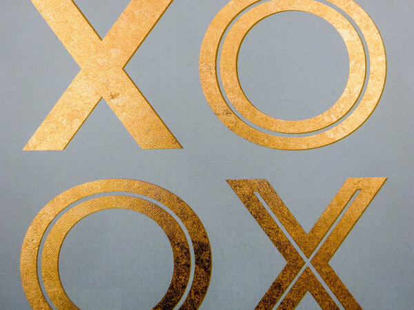 golden xoxo letters on canvas board