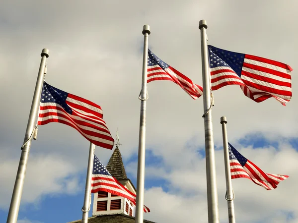 Red white and blue flags on a pole with american architecture — Stock Photo, Image