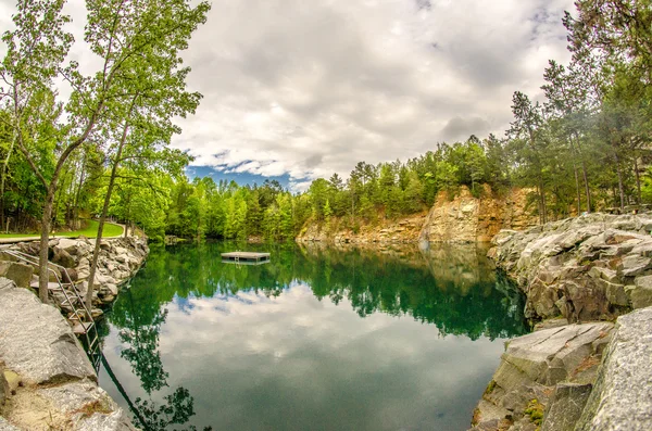 Cloudy skies and reflections at a quarry — Stock Photo, Image