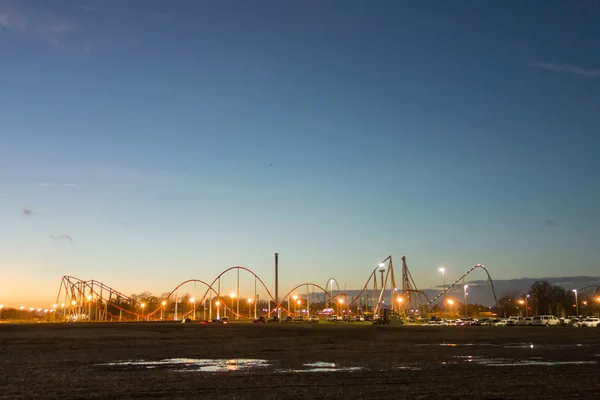 Sunset over an amusement park in a distance — Stock Photo, Image