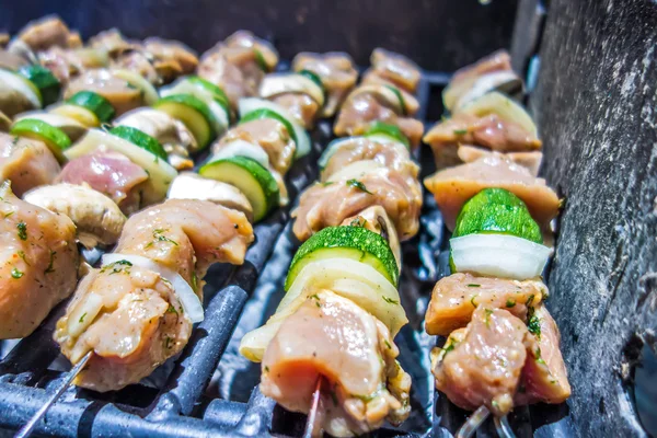 Shish kebab on skewers on a grill on a holiday — Stock Photo, Image