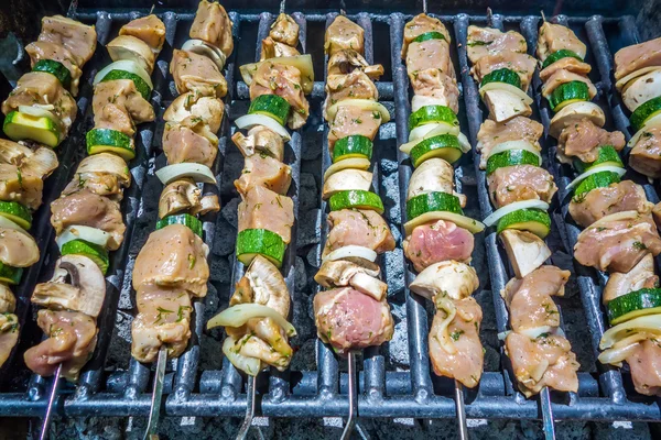 Shish kebab on skewers on a grill on a holiday — Stock Photo, Image
