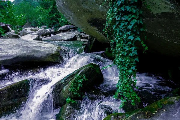 Fluss fließt über Felsformationen in den Bergen — Stockfoto