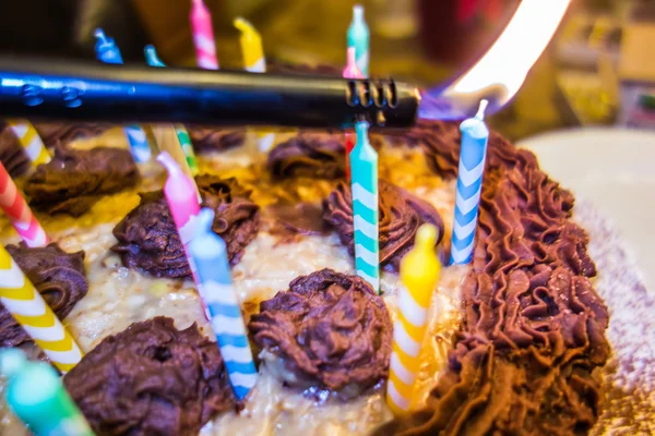 Iluminación velas de colores en pastel de cumpleaños —  Fotos de Stock