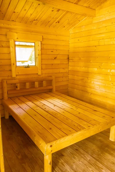 Pequeña cabaña de madera interior con cama y ventana — Foto de Stock