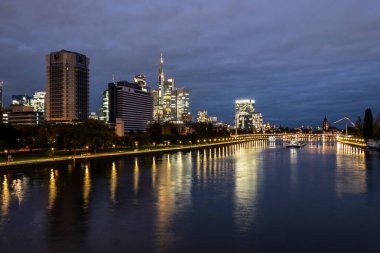 Akşamları Frankfurt silueti. Mavi saatte gün batımında finans ve iş bölgesinden aydınlık gökdelenlerle