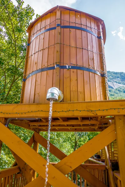 Cubo de madera con agua corriendo desde el grifo —  Fotos de Stock