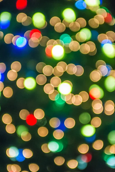 Desenfocado árbol de navidad luces en un fondo de la ciudad — Foto de Stock