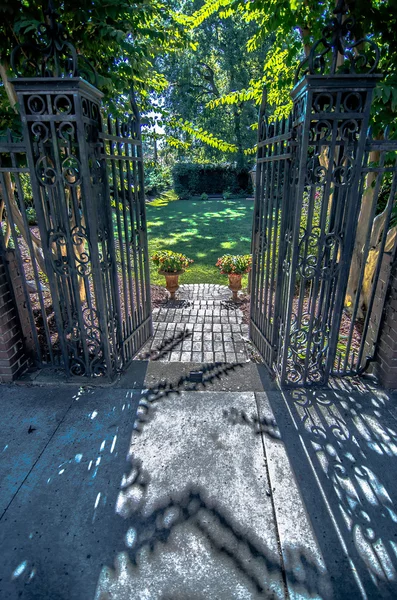 Klassiek design zwart gewrocht iron gate in een prachtige groene ga — Stockfoto
