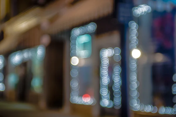 Defocused skyltfönster trottoaren lampor på natten — Stockfoto