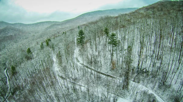 Vista aérea sobre montanhas e paisagem coberta de neve — Fotografia de Stock