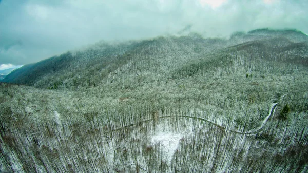 Vista aérea sobre montañas y paisaje cubierto de nieve — Foto de Stock