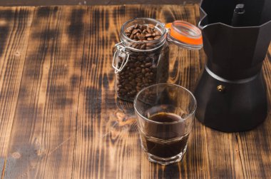 Ahşap bir masada cam bir kavanozda kahve. Seçici odaklanma. Tahta bir masada açık cam kavanozda kahve taneleri ve metin için arka plan