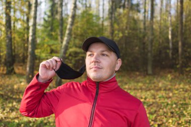Dışarıdaki adam Coronavirus 'un maskesini çıkarıyor. Dışarıdaki adam koronavirüsten siyah bir maske çıkarıyor..