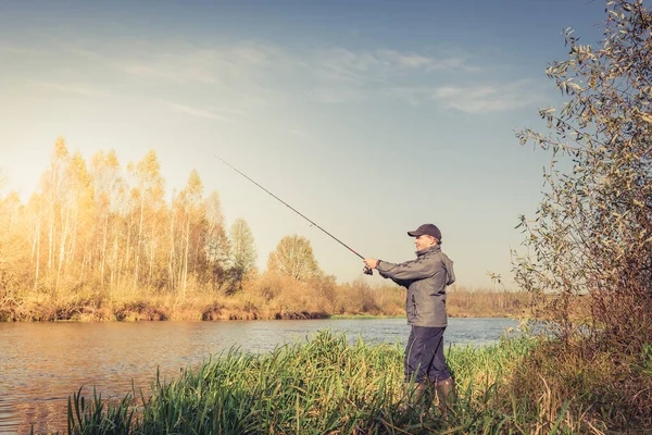 Homem Está Costa Com Uma Vara Pesca Pescador Uma Jaqueta — Fotografia de Stock