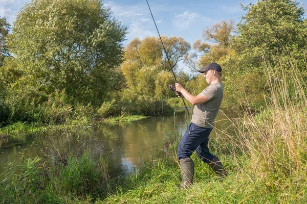 漁師は川のそばで釣り竿を持っている Sunney — ストック写真