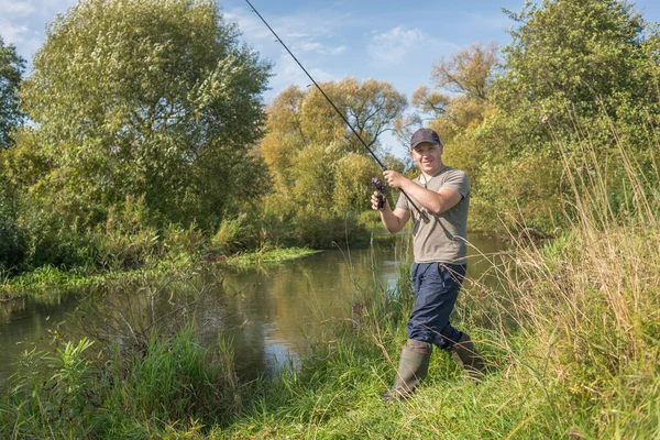 漁師は川のそばで釣り竿を持っている Sunney — ストック写真