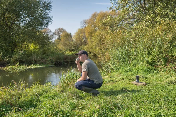 Giovane Con Una Tazza Siede Nella Natura Vicino Fiume Escursioni — Foto Stock