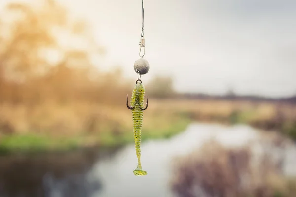 川の背景にフックにかかって釣りのためのシリコーン餌 釣りのためのタックル 自然の中でホビー釣り — ストック写真