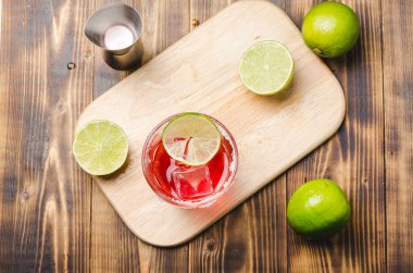 Ahşap bir masada kokteyl hazırlıyorum. İçkiyi bardakta buzla karıştırmak. Üst görünüm