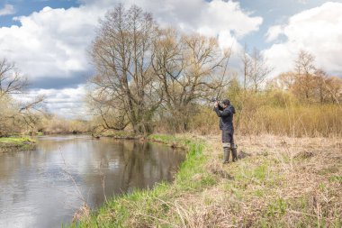 Balıkçılar kıyıya, gökyüzünün arka planına doğru bulutlu bir çubuk fırlatıyor..