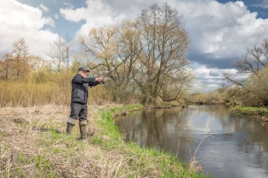 Balıkçılar kıyıya, gökyüzünün arka planına doğru bulutlu bir çubuk fırlatıyor..