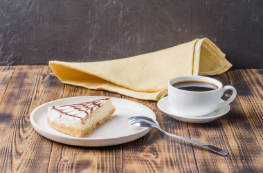 Beyaz tabakta bir fincan kahveli cheesecake.. 