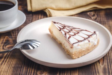 Beyaz tabakta bir fincan kahveli cheesecake.. 