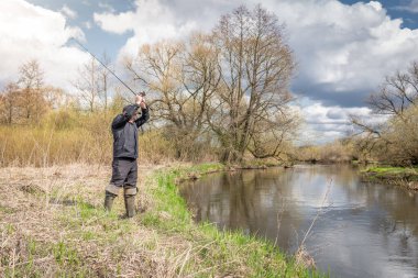 Balıkçılar kıyıya, gökyüzünün arka planına doğru bulutlu bir çubuk fırlatıyor..