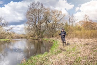 Balıkçılar kıyıya, gökyüzünün arka planına doğru bulutlu bir çubuk fırlatıyor..