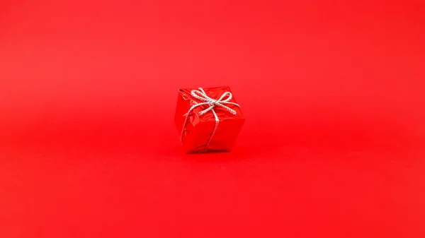 Красный подарок с красным фоном — стоковое фото