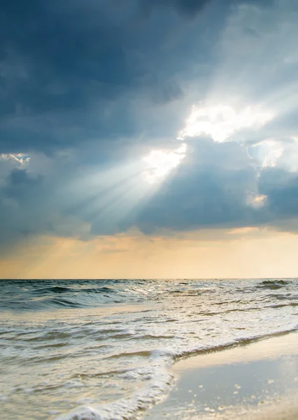 Rayos de sol rompiendo las nubes al atardecer — Foto de Stock