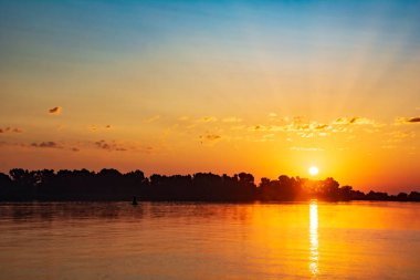 Ormanda, nehrin üzerinde gün batımı