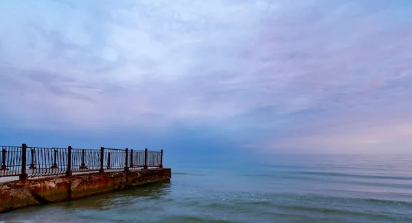 Beautiful sunrise on the old sea pier — Stock Photo, Image