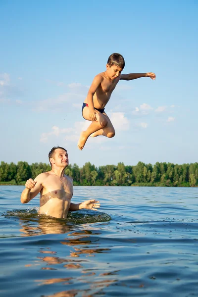 Tata rzuca się do syna w rzece — Zdjęcie stockowe