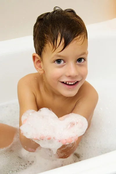 Rapaz bonito tomando um banho com espuma — Fotografia de Stock
