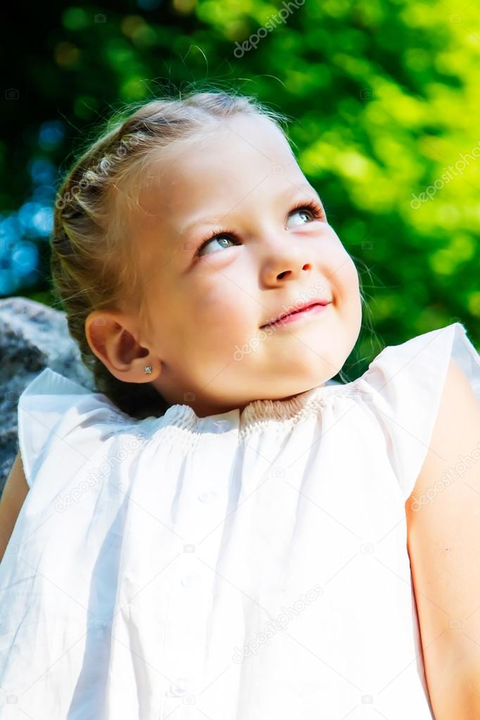 beautiful little girl in forest. looking up