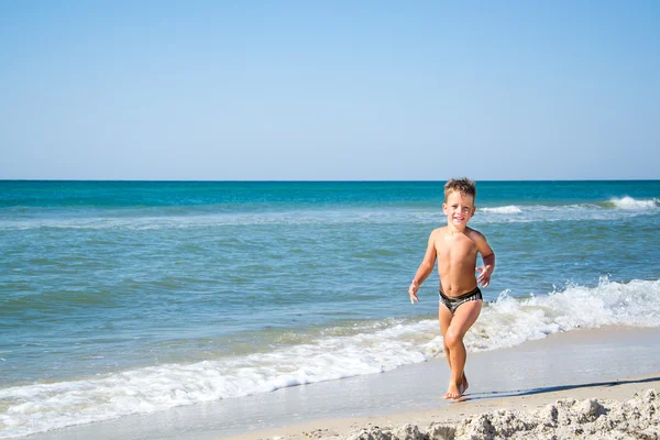 Söt fyra år pojke körs i havet — Stockfoto