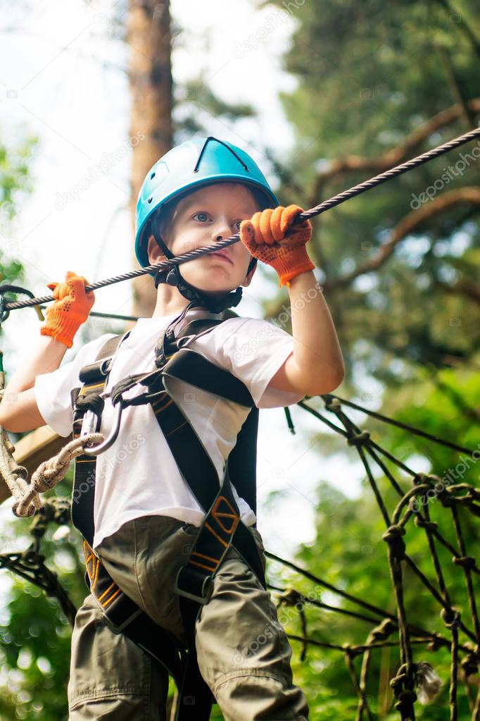 Five year boy on rope-way in forest