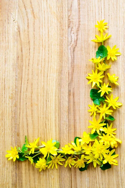 Background with yellow flowers over wooden table — Stock Photo, Image