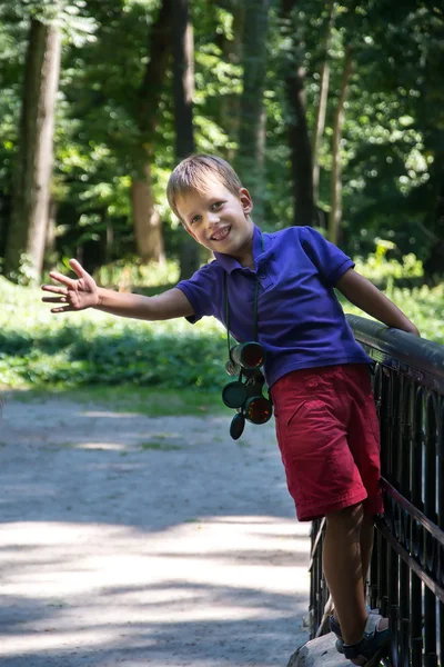Niño en puente estrechando su mano con prismáticos — Foto de Stock
