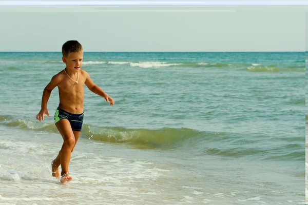 Liten pojke kör på sommaren på havet stranden — Stockfoto